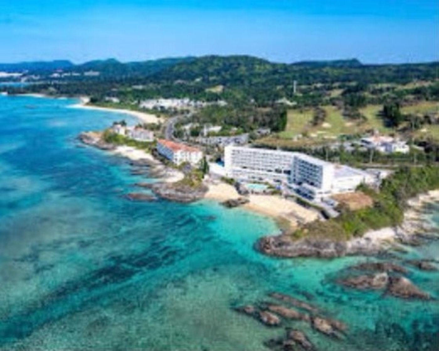 沖縄の海辺に建つリゾートホテルと青い海